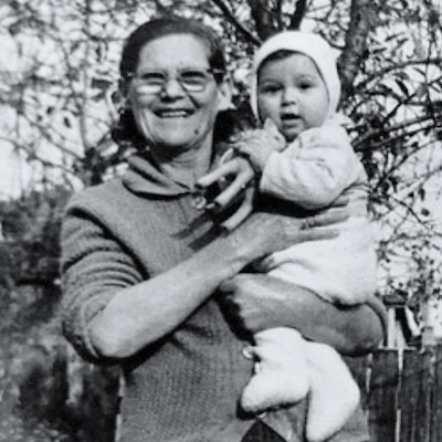 Photo of Bonda Dimiškova holding a child, both facing the camera